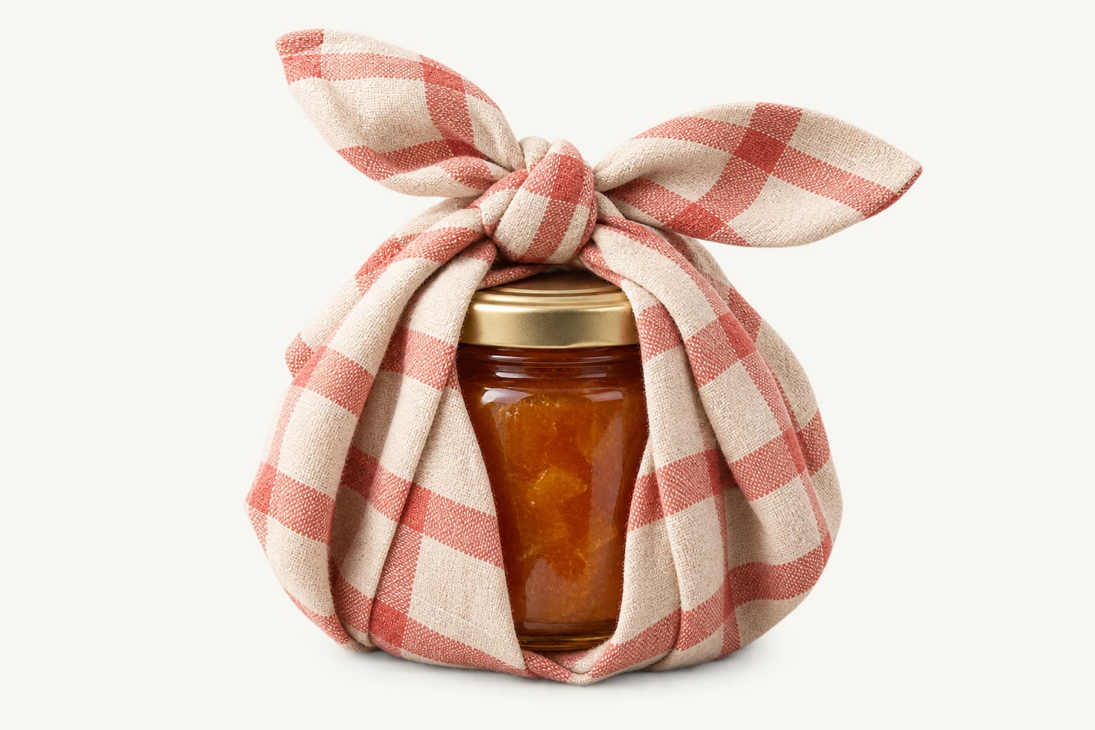 A jar of jam wrapped in red gingham cloth and knotted at the top