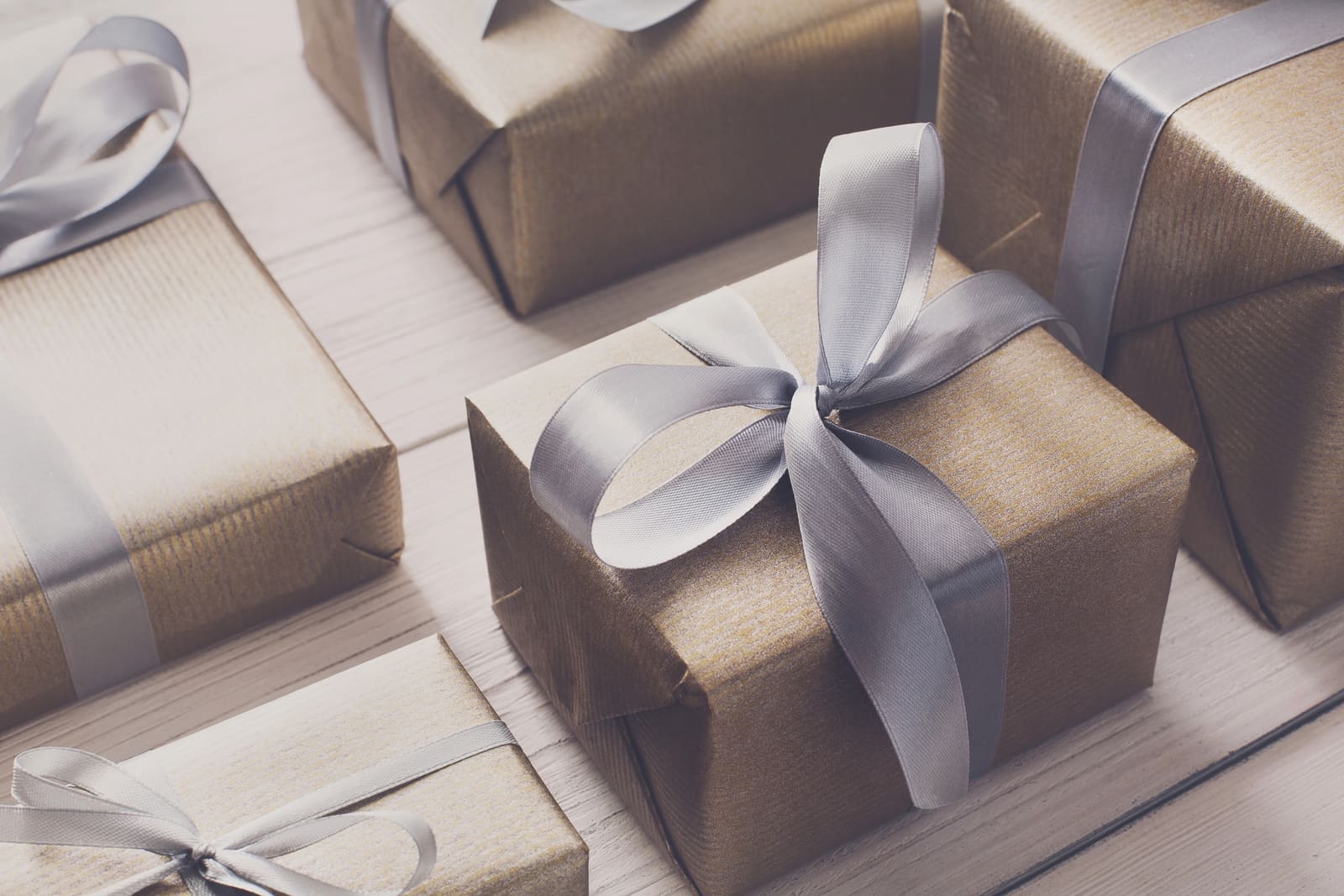 Gifts in shimmering bronze paper tied with silver satin ribbon
