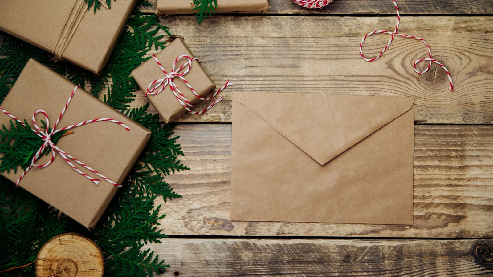 A kraft envelope beside parcels tied with red and white twine