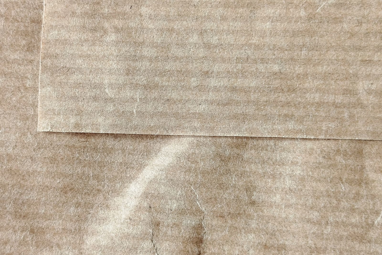 Close-up of kraft paper with a folded edge, showing its ribbed texture