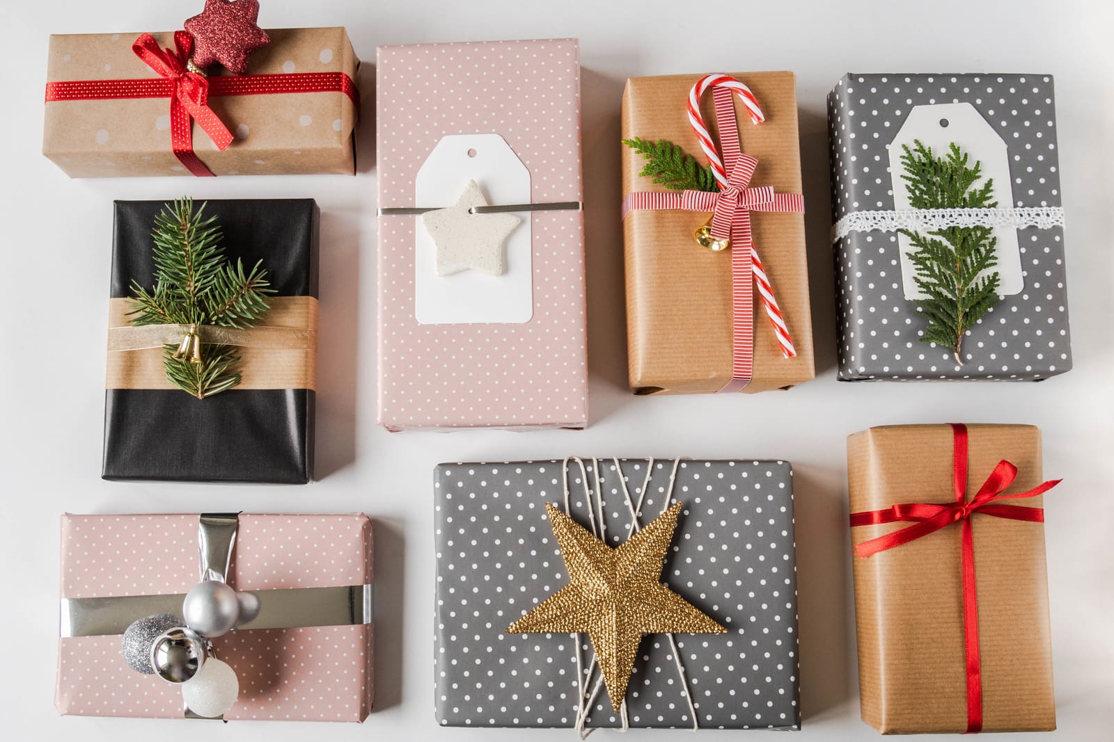 Gifts in pink, grey and kraft paper with dots, ribbons and fir sprigs