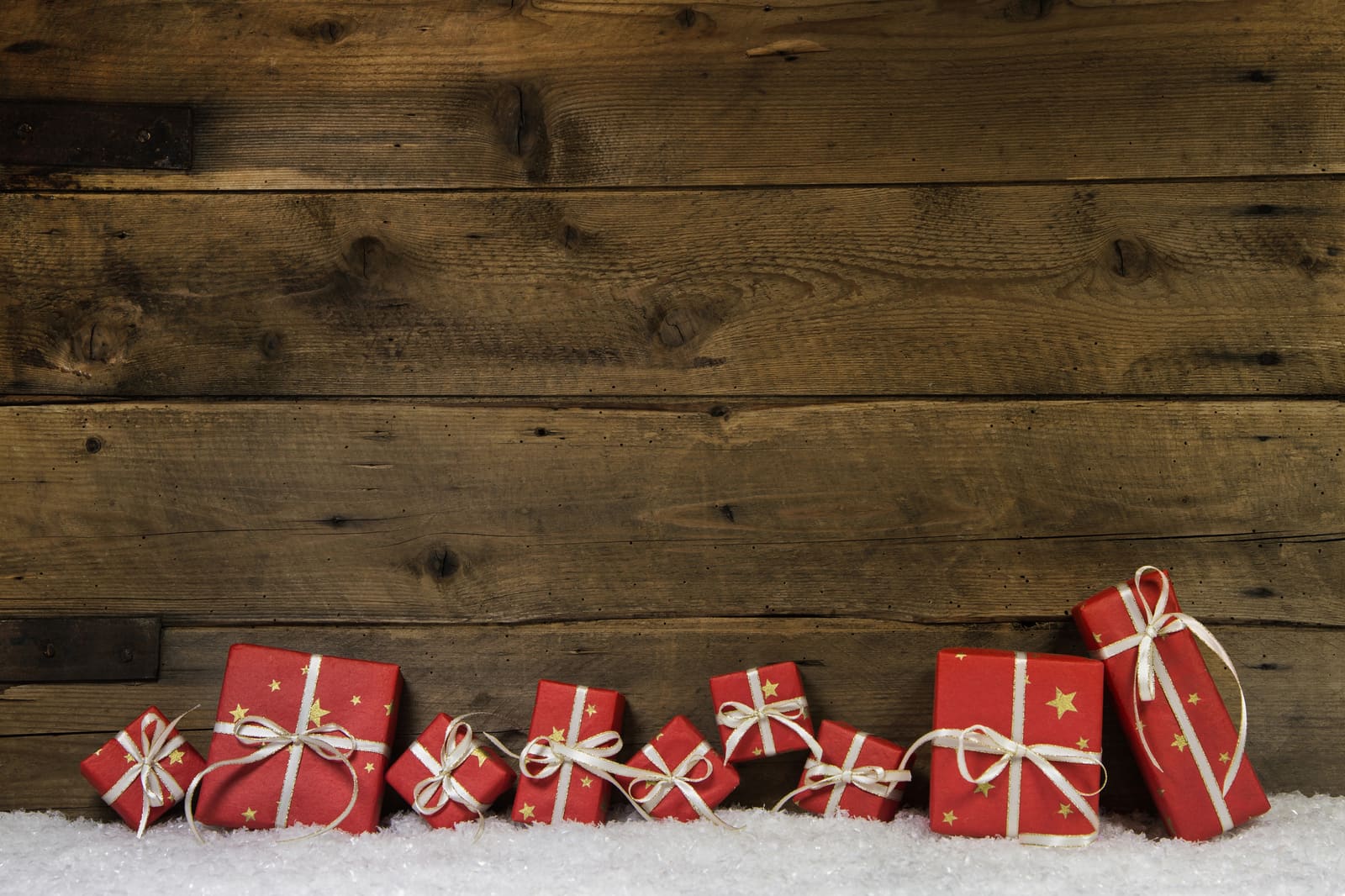 Small red star-print parcels tied with white string against old wood