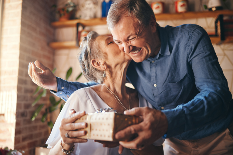 Elderly couple celebrating their anniversary by giving each other gifts