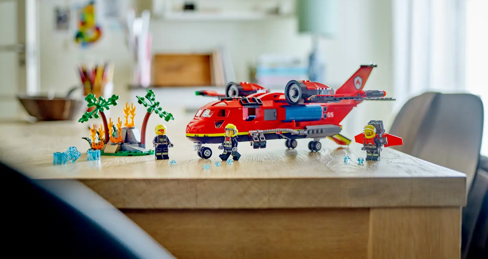 Aereo di soccorso antincendio LEGO City con minifigure di pompieri e scena di incendio boschivo