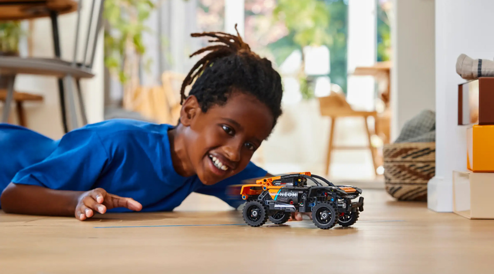 Chłopiec bawiący się zdalnie sterowanym samochodem LEGO Technic